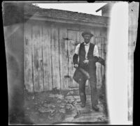 Charles White stands at a pump on Uncle White's farm, Kirkwood vicinity, [circa 1890s?]