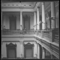 Wilhelmina West looks down from a balcony in the Colorado State Capitol building, Denver, 1900
