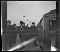 People walk off of a train and on a subway platform, New York, 1914
