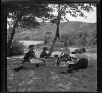 Hattie Cline, Elizabeth West, Mary West and Wilfrid M. Cline lunch under the trees at Elizabeth Lake, Lancaster vicinity, about 1912