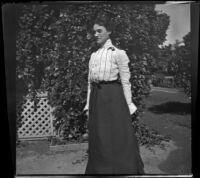 Lelia Gillan poses in front of a tree and fence, Fresno, 1901