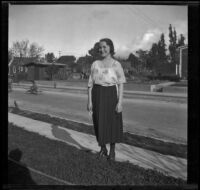 Frances Cline poses for a photograph in front of a street, Glendale, about 1920