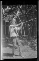 H. H. West, Jr. draws back a bow and arrow, Glendale, about 1924