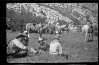 Guide Robinson, Charles Stavnow, Cleo Swain, and Glen Velzy resting their train of horses at Onion Flat during a trip to Gardner Creek, about 1919