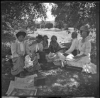 Mary West, H. H. Cooper, Elizabeth and Frances West, Wilhelmina West, and an unidentified woman sit around a picnic blanket, Glendora, about 1910