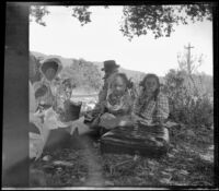 Wilhelmina West, Mary West, H. H. Cooper, and Frances and Elizabeth West sit around a picnic blanket, Glendora, about 1910