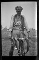 Jesse Brown poses with 5 trout, June Lake, about 1920
