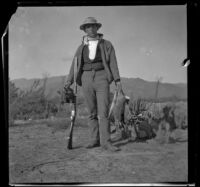 Bob Brain poses with quails and rabbits, Irwindale, about 1900