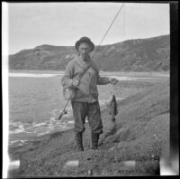 Glen Velzy carries both a fish he caught and his fishing rod, Laguna Beach, 1914