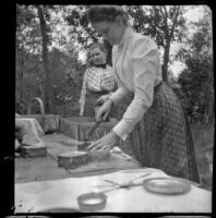 Margaret Burris holds a knife while Fannie Mead Biddick looks on, Elliott vicinity, 1900