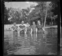 H. H. West stands in an outdoor swimming pool known as Lewis Lake with his cousins and friends, Elliott vicinity, 1900
