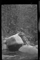 H. H. West, Jr. leans against a boulder and fishes in Matilija Creek, Ojai vicinity, about 1925