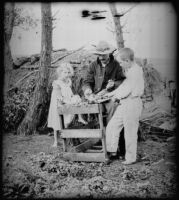 Grace and Walter Biddick help William Mead pluck a chicken, Elliott vicinity, 1900