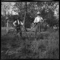Daniel Mead holds a scythe while an unidentified man stands next to him with a bicycle, Elliott vicinity, 1900