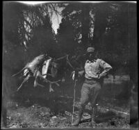 H. H. West poses with the first deer he shot and a pack horse, Olancha vicinity, 1914