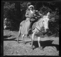 Mary West and Frances West pose while sitting on a donkey, Mount Wilson, about 1909