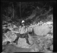 Elizabeth West sitting on a rock in a stream, Mount Wilson, about 1909