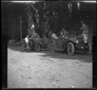 Al Schmitz and Glen Velzy standing by the cars stopped on the side of a road, Mendocino County vicinity, 1915