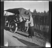 Mary West walking past H. H. West's Buick, Mendocino County vicinity, 1915
