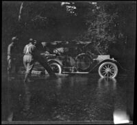 Three men working to get H. H. West's Buick out of Big River, Mendocino County, 1915