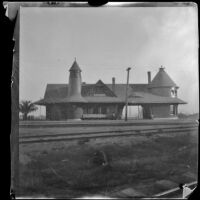 Raymond Hotel Santa Fe Railroad station, viewed from across some railroad tracks, Pasadena, about 1898