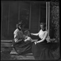 Grace Butterfield and Claude Bishop sit on a porch with a baby and child, Red Oak, 1900