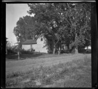 Sam Longstreet leans on a post in front of a house, Red Oak, 1900
