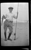 Everett Shaw posing with a fish and fishing rod near Rincon Point, Carpinteria vicinity, about 1924