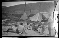 Members of the West, Shaw and Whitaker camping party sitting on the beach near their campsite, Carpinteria vicinity, about 1924