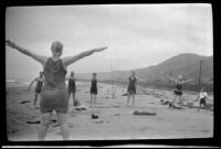 Josie Shaw raising her arms as she leads drills on the beach near Rincon Point, Carpinteria vicinity, about 1924