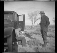 H. H. West, Jr. and Glen Velzy drinking hot chocolate by the car, Rosamond, about 1930