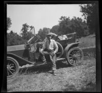 H. H. West leaning against a car, Westlake Village, about 1915
