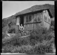 Roy Bagley sitting outside his cabin, Westlake Village, about 1915
