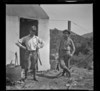 Henry Robinson and Glen Velzy posing outside a cabin, Westlake Village, about 1915