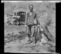 Romayne Shaw holds fish and fishing gear, Mono County vicinity, 1929