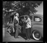 Forrest Whitaker and Perl Guptill talking baits while standing next to a car, Independence, 1941