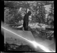 H. H. West in camp, inspecting his waterwheel, Mono County, 1941