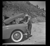 Forrest Whitaker filling the radiator of his Ford, Mono County, 1941