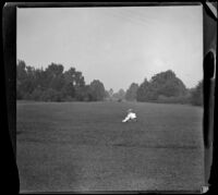 Woman sits in a meadow in Golden Gate Park, San Francisco, 1900