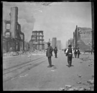 Guy West stands in a street lined with buildings destroyed by the San Francisco Earthquake and Fire, San Francisco, 1906