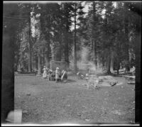 Mary and Frances West stand near cars and a campsite, Burney vicinity, 1915