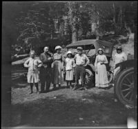 Frances West, Adolph and Charlotte Bystle, Elizabeth West, William "Babe" Bystle, Wilhelmina West, and Mary West stand by cars in a forest, Burney vicinity, 1915