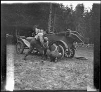 Wilfrid Cline, Jr. and two others fixing a flat tire on Ade Bystle's Ford, Trinity County, 1917