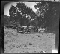 Harry Schmitz and Wilfrid Cline, Jr. stand in the campsite on a bank of Cow Creek, Redding vicinity, 1917