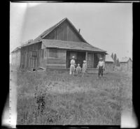Wilfrid Cline, Jr. and members of the Bidwell family stand outside the Bidwell's home, Shasta County, 1917