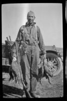Harry Schmitz posing with two limits of sage hen at Coon Camp, Lassen County, 1917