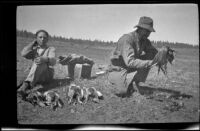 Wilfrid Cline, Jr. and Harry Schmitz cleaning sage hen at Coon Camp, Lassen County, 1917
