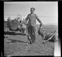 Wilfrid Cline, Jr. posing with two limits of sage hen at Coon Camp, Lassen County, 1917
