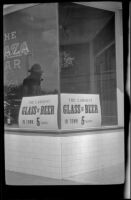 Signs for "The Largest Glass of Beer in Town... " sit in a storefront window, Reno, 1917