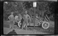 Wilfrid Cline, Jr. and Harry Schmitz standing by a road sign and H. H. West's Buick, Cisco, 1917